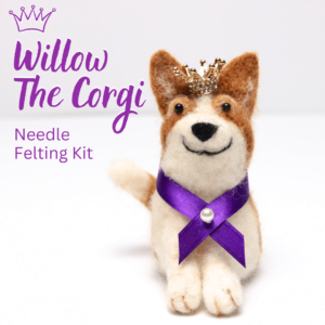 Needle felted corgi wearing a crown and royal purple sash with pearl