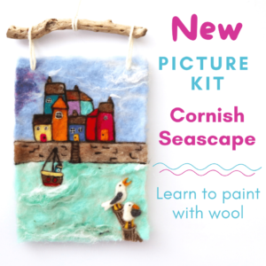 Image shows a needle felted seaside scene with harbour, brightly coloured houses, boat and two seagulls. Text on image reads: New picture kit. cornish seascape. Learn to paint with wool.
